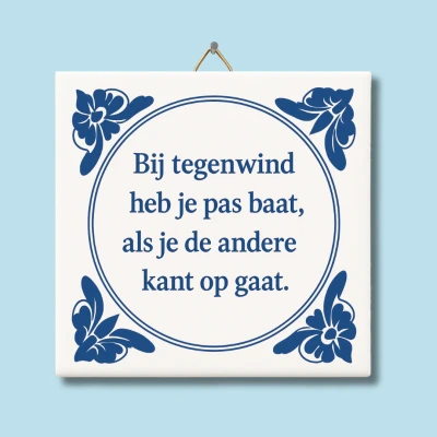 Afbeelding van NietMokken.nl Grappig tegeltje met tekst: &quot;Bij tegenwind heb je pas baat, als de andere kant op gaat.&quot; 15x15 cm keramiek Cadeau knipoog Delfts blauw Inclusief ophanghaakje Spreukentegeltje