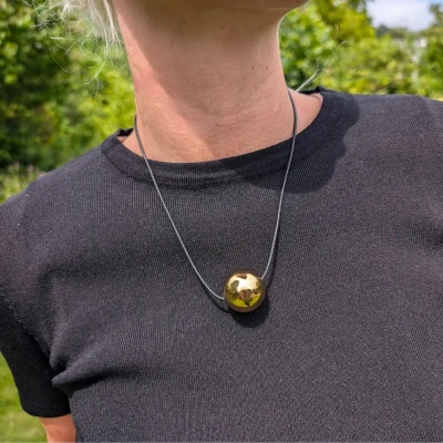 Afbeelding van Zwart koord ketting met grote gouden bal
